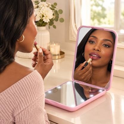 Woman using the pink mirror for a lipstick touch-up